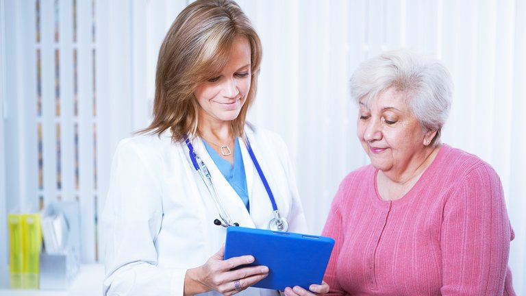 Un médecin et une patiente consultent une tablette