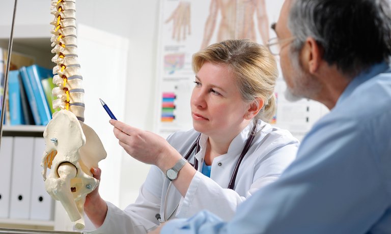 Un médecin explique à son patient la maladie métabolique osseuse, une complication possible de l’IRC