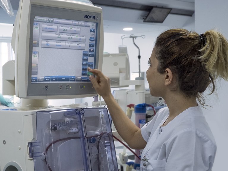 Nurse working on a dialysis machine